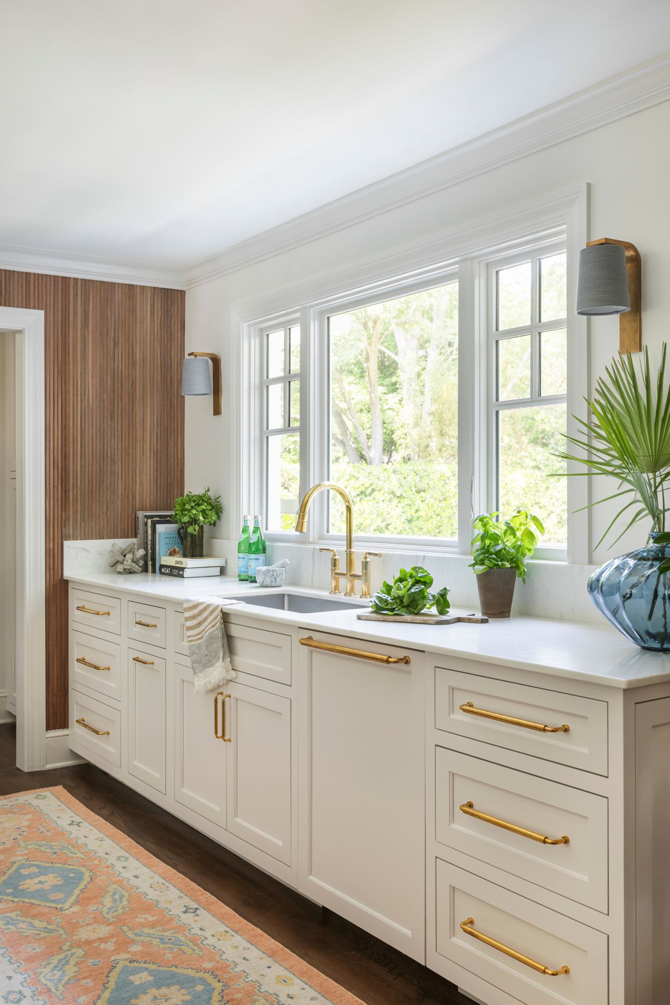 Bright custom kitchen with brass hardware and garden window